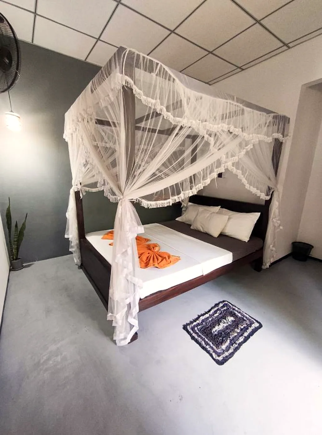 A canopy bed dressed in white linen