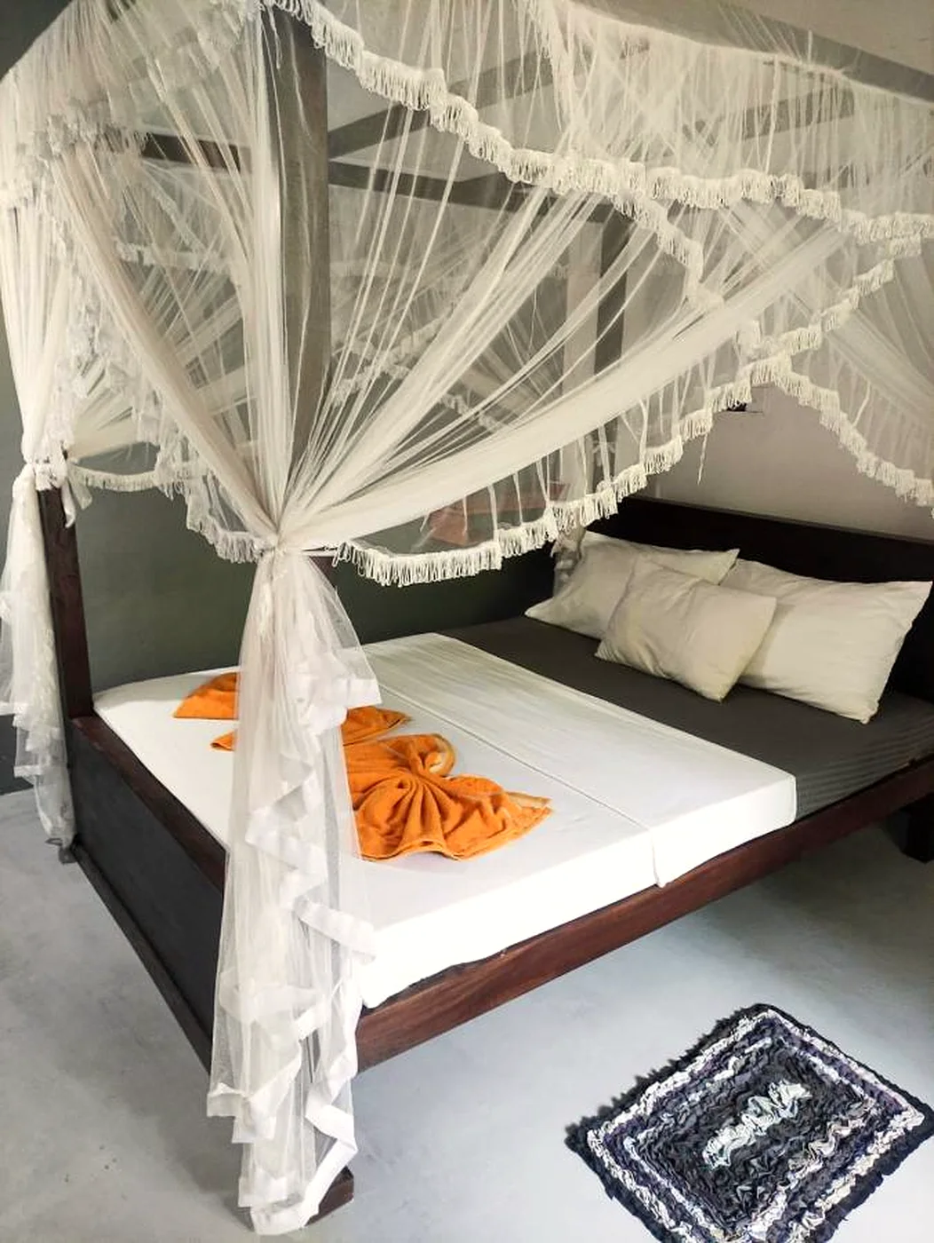 Deluxe Veranda Room with mosquito net canopy and mustard accents