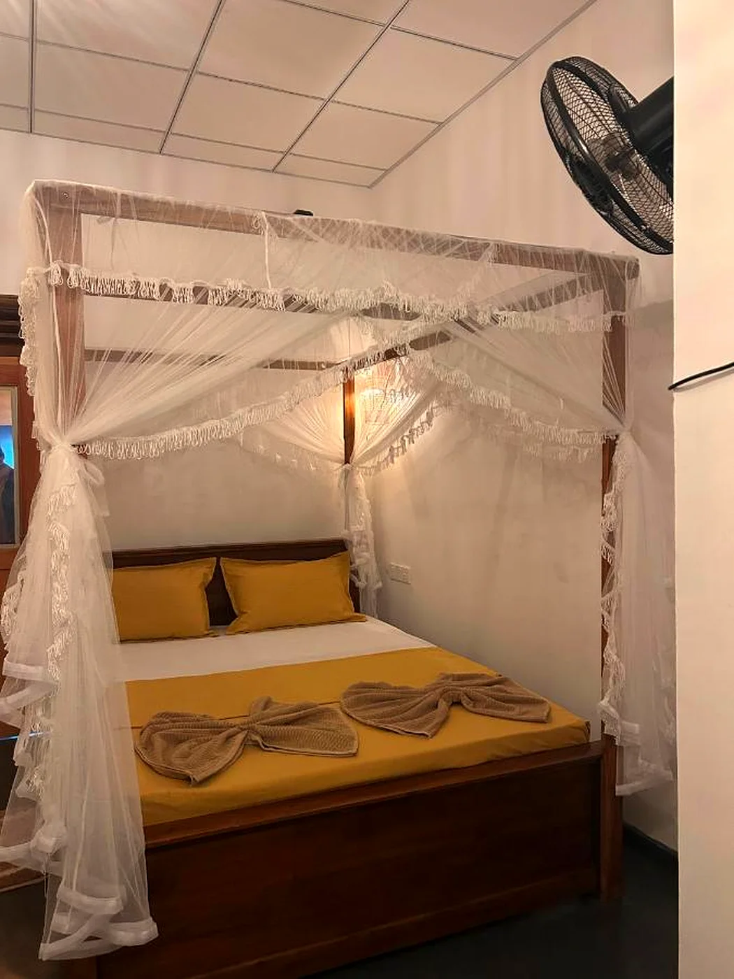 Deluxe Garden Room with a four-poster mosquito net and warm linens